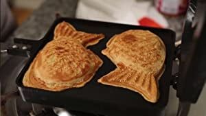 Two taiyaki cooking in a pan