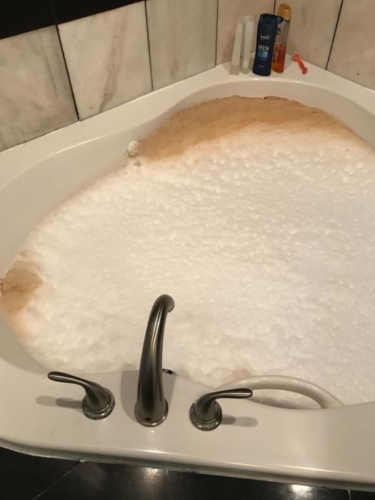 A bubbly jet tub with brown residue coming out from the vents.
