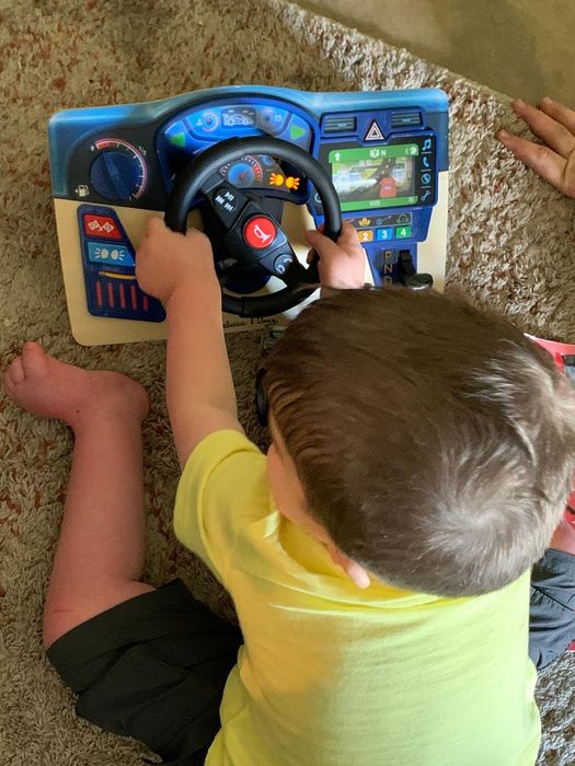 A child using the interactive wooden dashboard for play