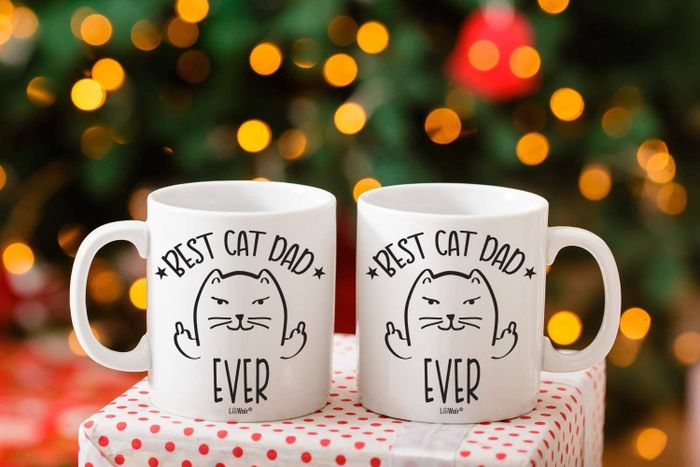 Two white mugs featuring a cartoon cat design with the phrases 'Best Cat Mom Ever' and 'Best Cat Dad Ever'
