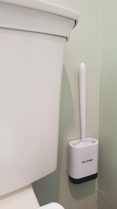 The reviewer’s toilet brush is mounted on the wall.