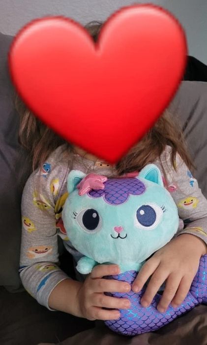 A reviewer's child cuddling the soft and huggable plush MerCat toy.