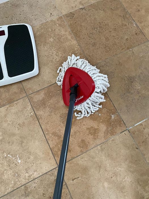 The reviewer is shown using the mop to clean the floor.
