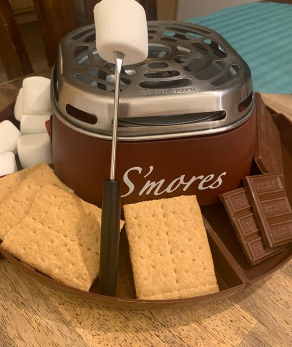 graham crackers, marshmallows, and chocolate surrounding a s'mores grill