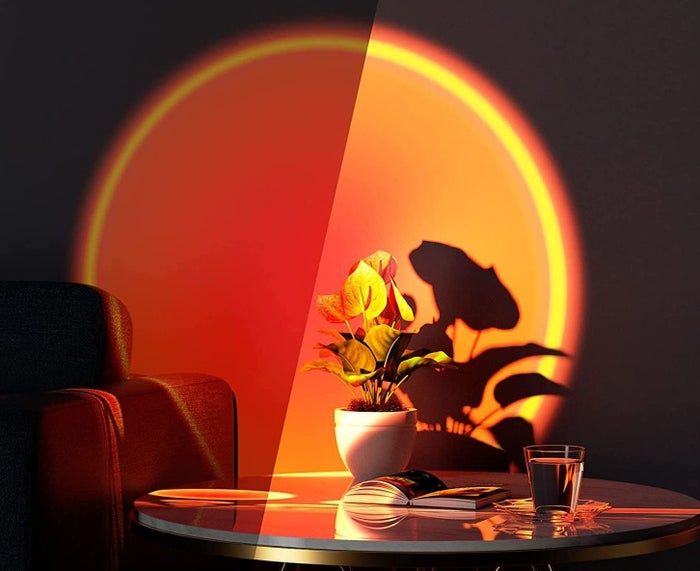 lamp casting a warm orange glow on the wall behind a coffee table and plant