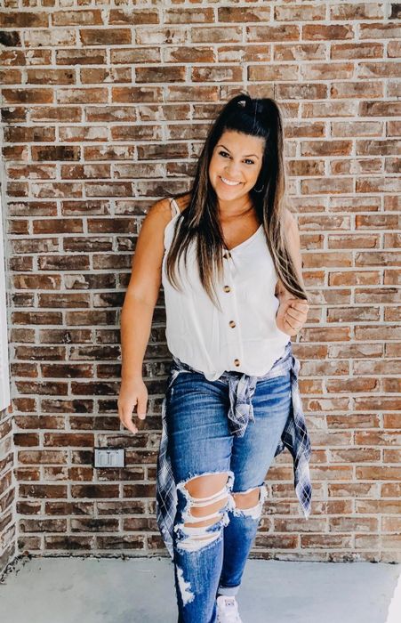 A reviewer wearing the white tank with jeans