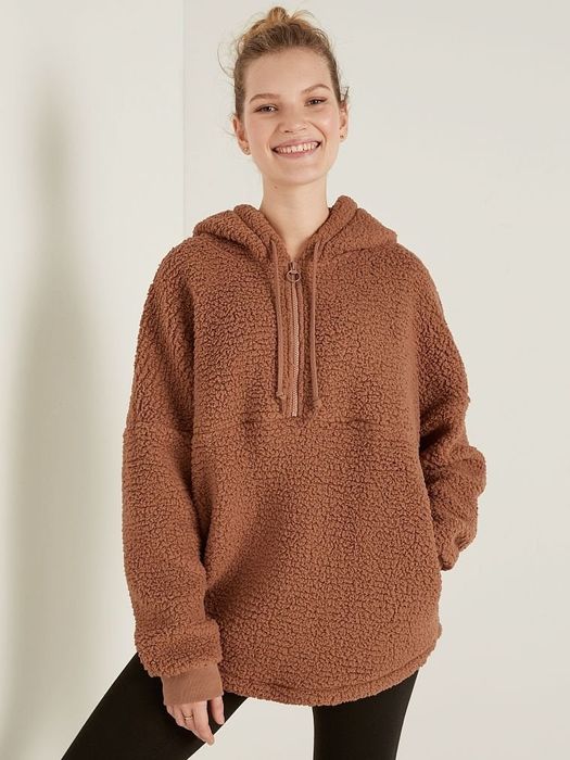 A model wearing a brown fuzzy half-zip pullover.