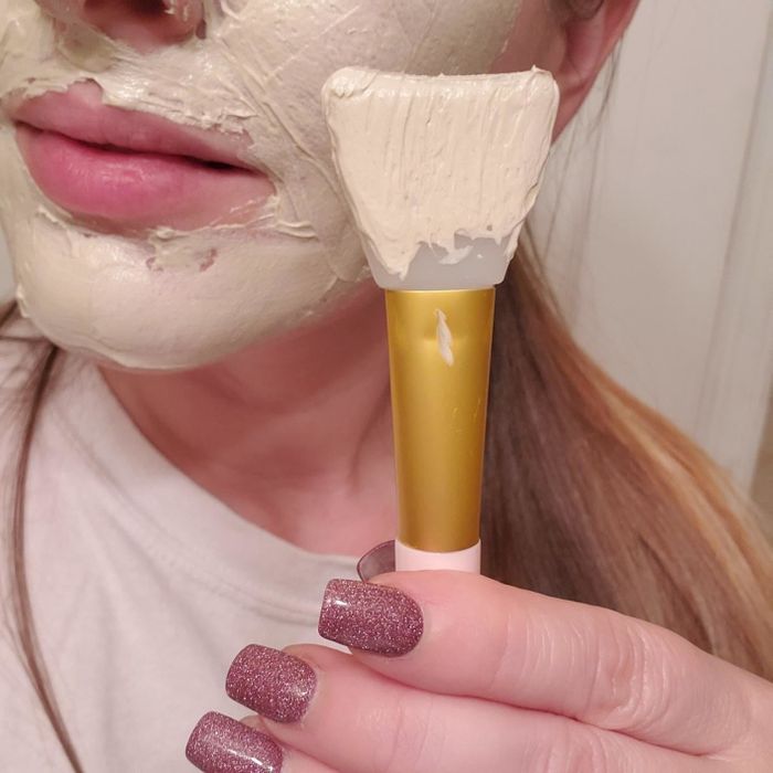 the reviewer using the spatula brush to apply a mask