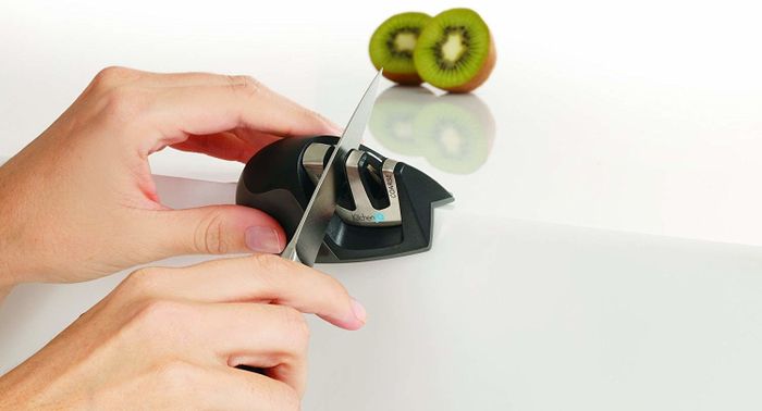 a reviewer using the small handheld tool to sharpen their knives
