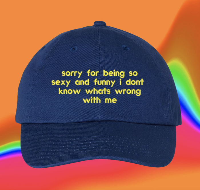 A royal blue hat featuring yellow embroidery with the humorous phrase,