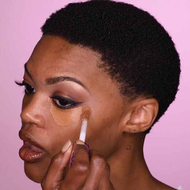 a model applying Shape Tape under their eyes