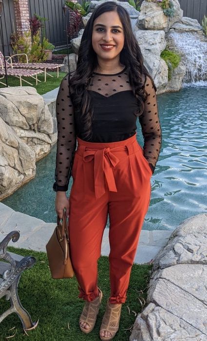 Reviewer wearing red high-waisted pants