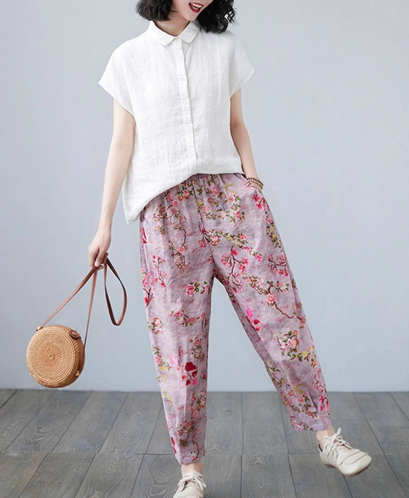A model showcasing the vibrant pink floral pants.