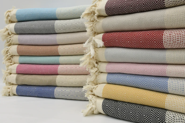 Two piles of colorful blankets in various shades and patterns.