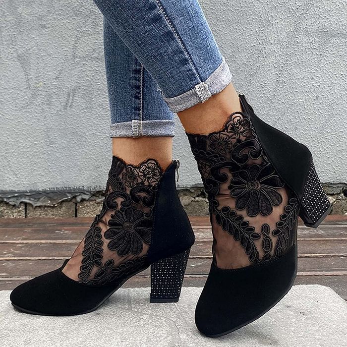 Model wearing the black lace-up heeled boots paired with cuffed jeans