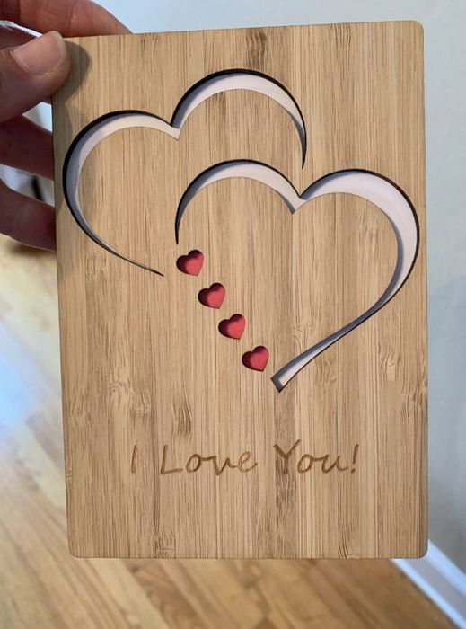 A photo from the reviewer showing the wooden card with a heart design and the engraving 'I Love You!'