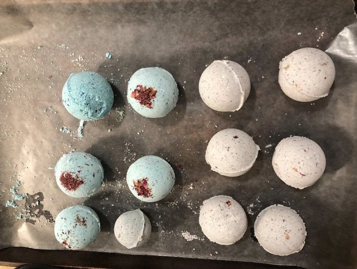 A picture shared by the reviewer of a baking sheet holding both white and blue bath bombs.