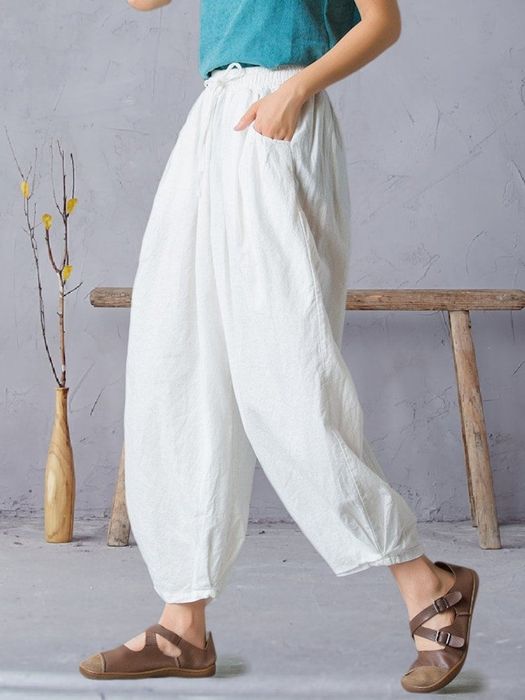 A model confidently sporting the white pants with a polished look.