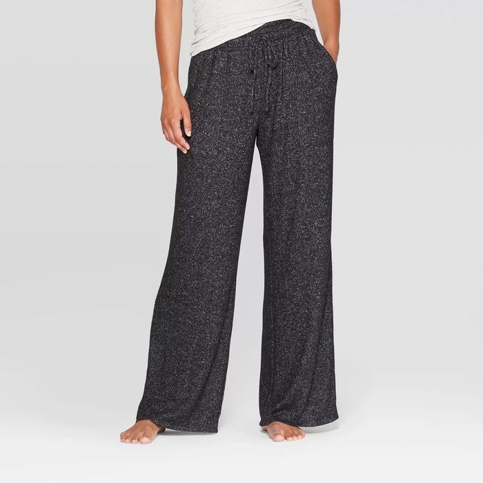 A person styling loose, casual black speckled pants that are perfect for relaxing or casual shopping trips