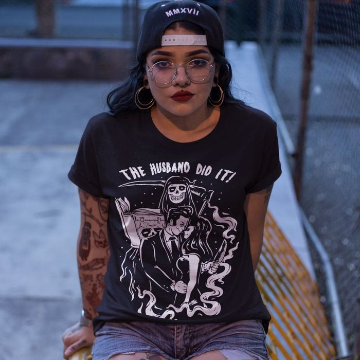 A model wearing a black tee featuring the text