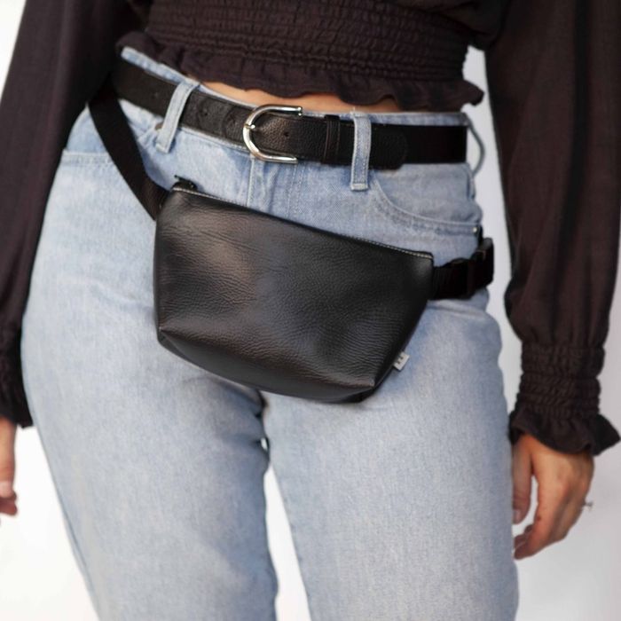 A model showcasing a chic black belt bag.