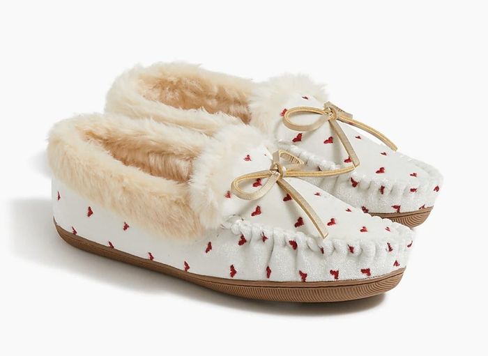 White moccasin slippers adorned with vibrant red embroidered hearts.