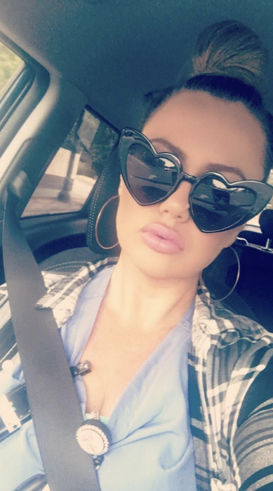 a reviewer modeling black heart-shaped sunglasses