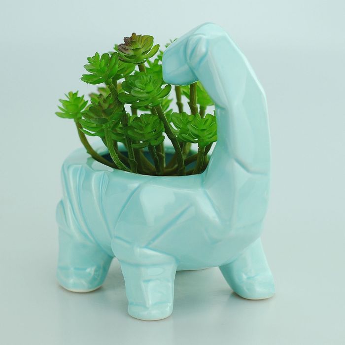 a vibrant blue ceramic planter shaped like a dinosaur, perfect for adding a playful touch to your indoor or outdoor space