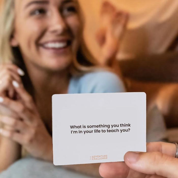 A person holding up a card with someone else visible in the background