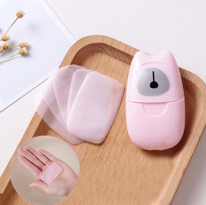 The pink plastic container featuring adorable ears and a nose, alongside delicate pink soap sheets.