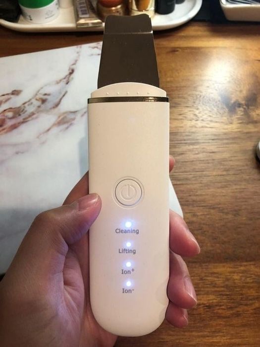 A close-up of a reviewer holding the skin scrubber.