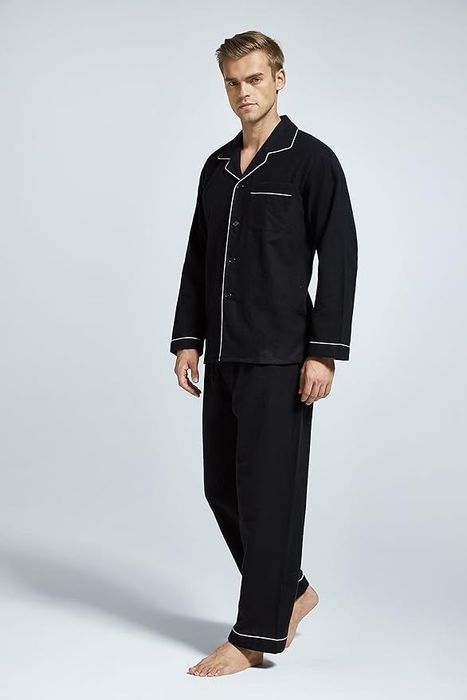 A model showcasing the black pajamas with white piping details