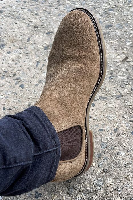 A reviewer modeling the tan boots