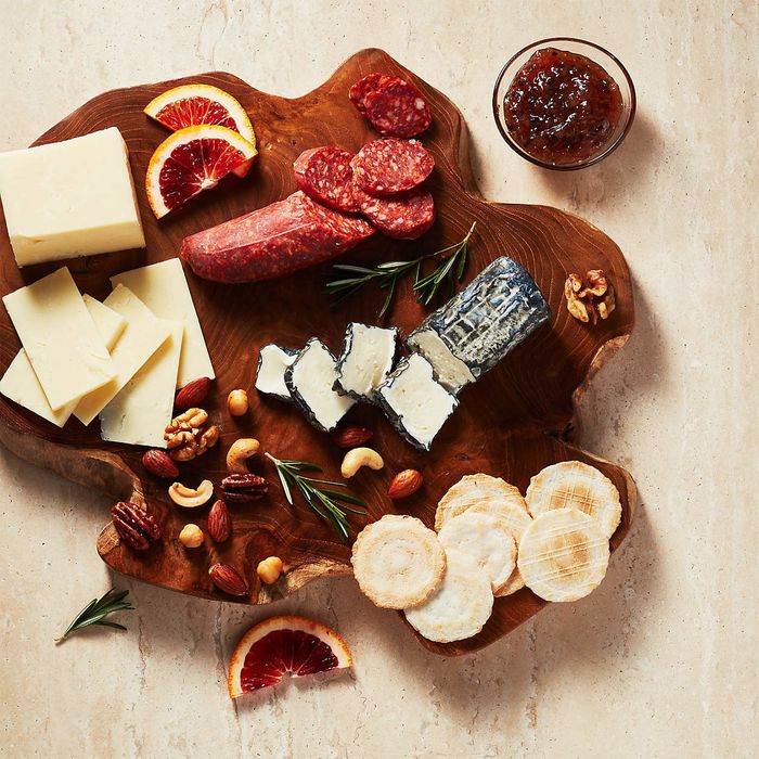 A reclaimed board piled high with delicious cheeses.