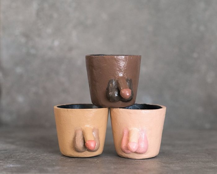 Three handcrafted pots, each shaped like a penis with testicles, available in various skin tone shades