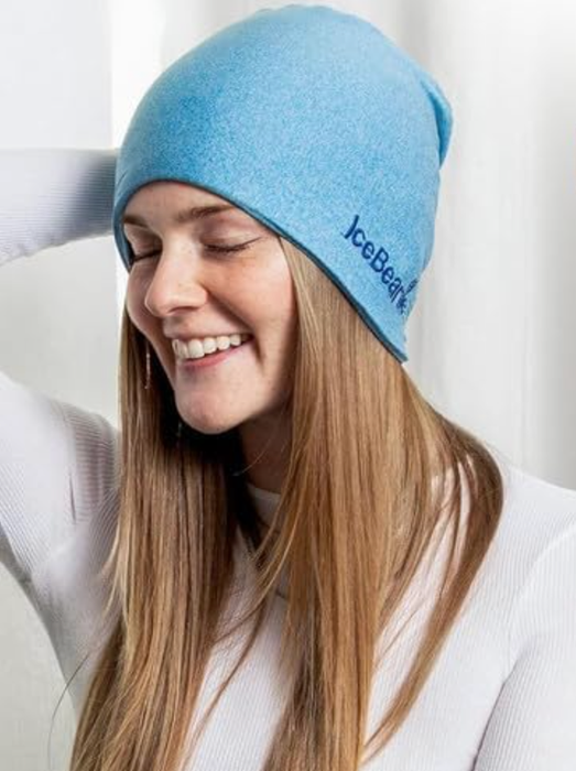 A model wearing a blue beanie and smiling.