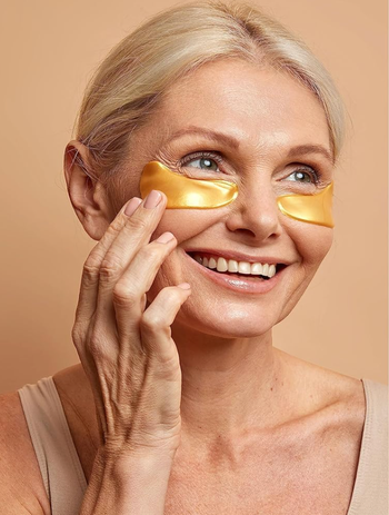 model grinning while wearing shimmering gold eye masks