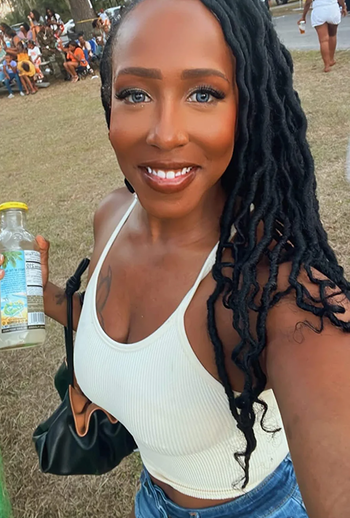 A reviewer wearing a white ribbed tank top with stylish straps