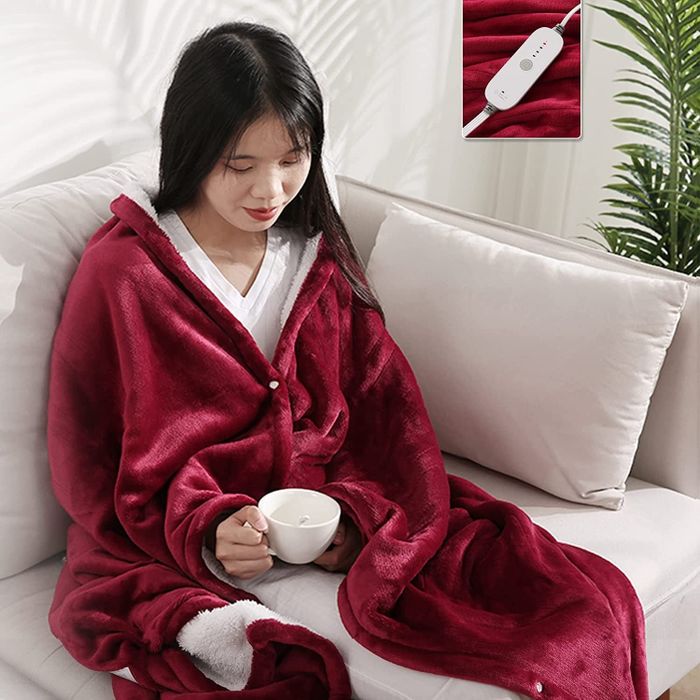 A model draped in the rose-red blanket, wrapping it around their shoulders.