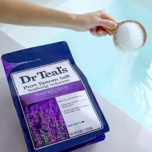 someone pouring epsom salt into a bath
