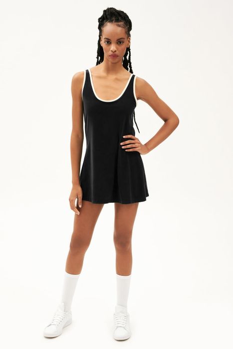A figure dressed in a sleek black tennis outfit featuring white accents near the neckline