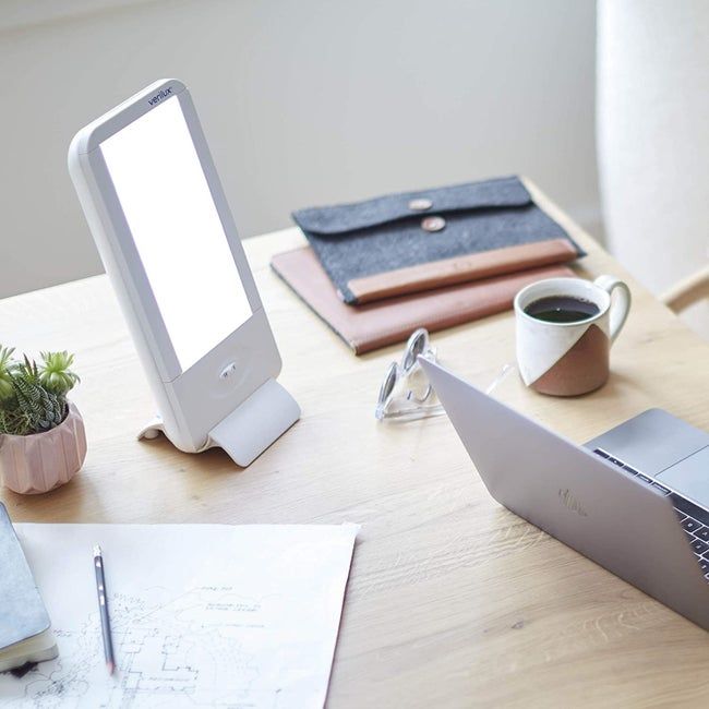 The rectangular sunlamp resting on a counter, next to a pour-over coffee setup