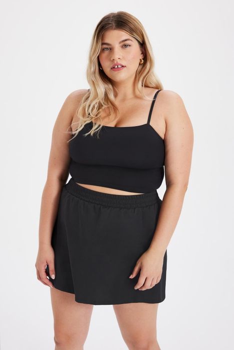 a model wearing a black cami paired with the skort