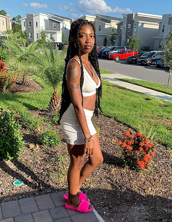 A reviewer modeling the white bike shorts and matching v-neck bra
