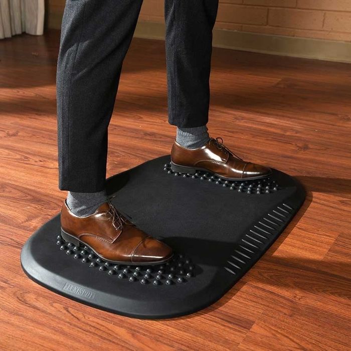 A model standing on the mat, demonstrating its comfort and support.