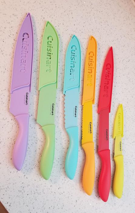 Five colorful Cuisinart knives with protective covers, varying in size from large to small, neatly arranged on a countertop.