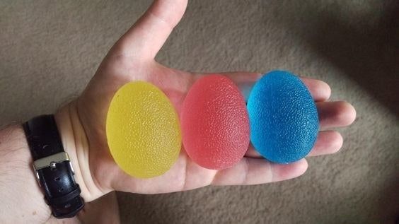 Three differently colored eggs held in the reviewer’s hand