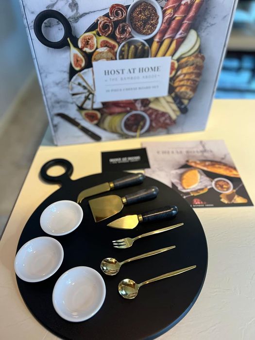 A refined gourmet cheese board set complete with utensils and small bowls, perfect for showcasing culinary creations at home or for elegant hosting occasions.