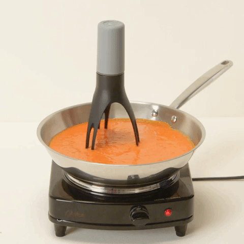 The automatic pan stirrer actively stirring a simmering sauce.