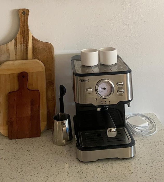 The white cups sitting atop a coffee maker